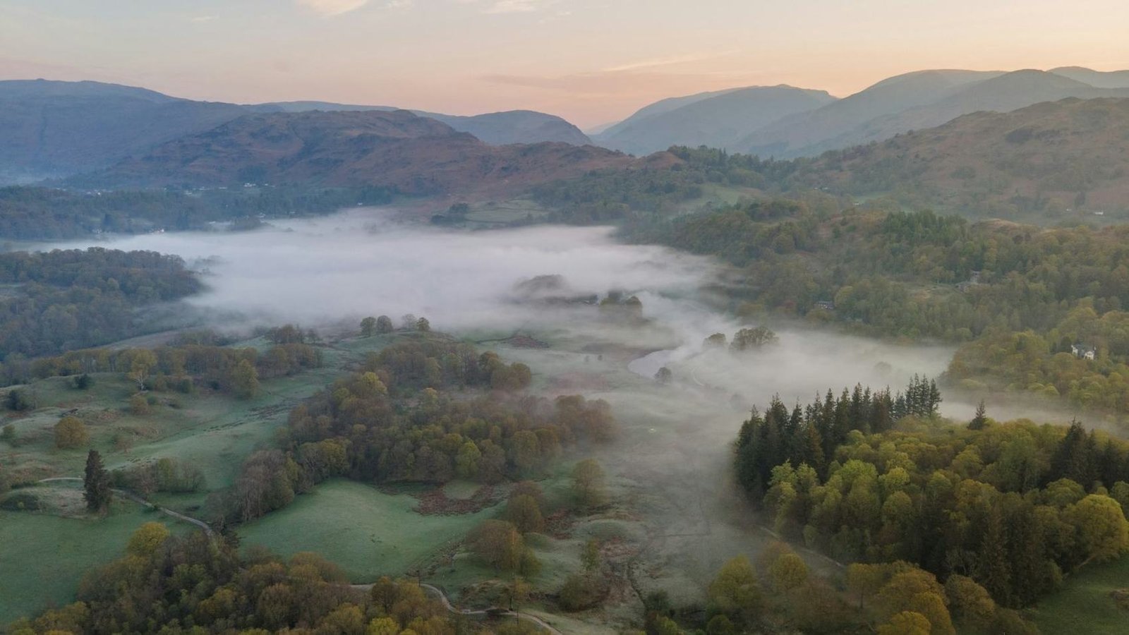 Valle del Lake District avvolta dalla nebbia del mattino d'autunno